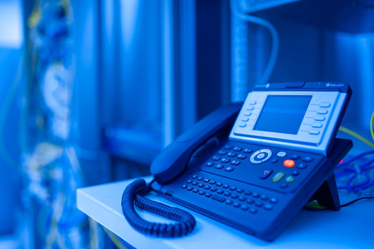 Close-up of a modern office phone in blue lighting. Ideal for tech and business themes.